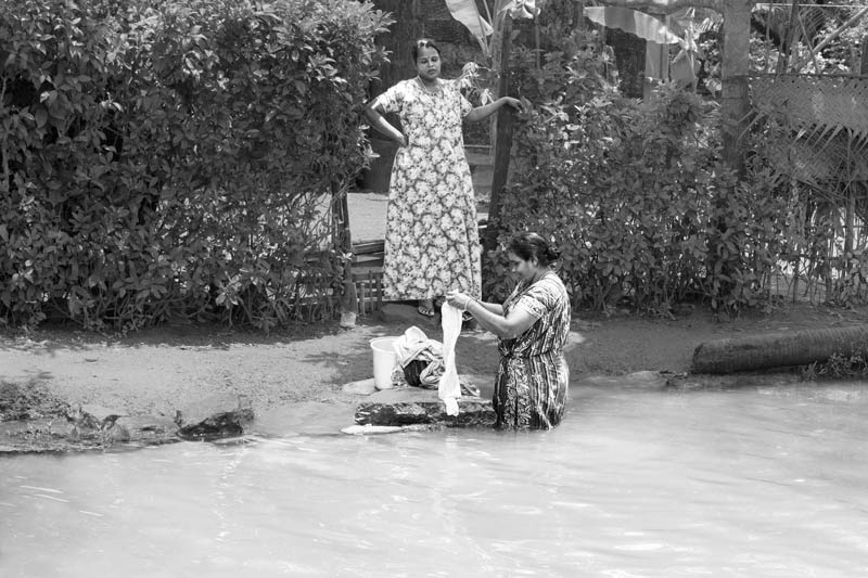 Living Below the Sea Level - Performing laundry on the banks of a Pamba river channel in Alappuzha district, Kerala